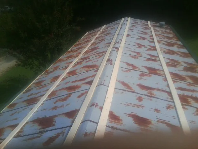 Rusted metal roof panels with new wood purlins before replacement — Storm Damage Roof Repair in Sartell by Roofing Brothers