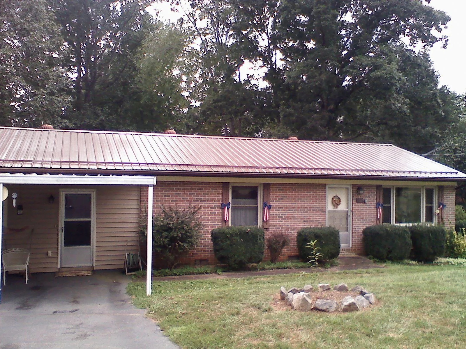 Bronze metal roof and carport on a brick ranch home — Roof Repair work by our crew in Sartell